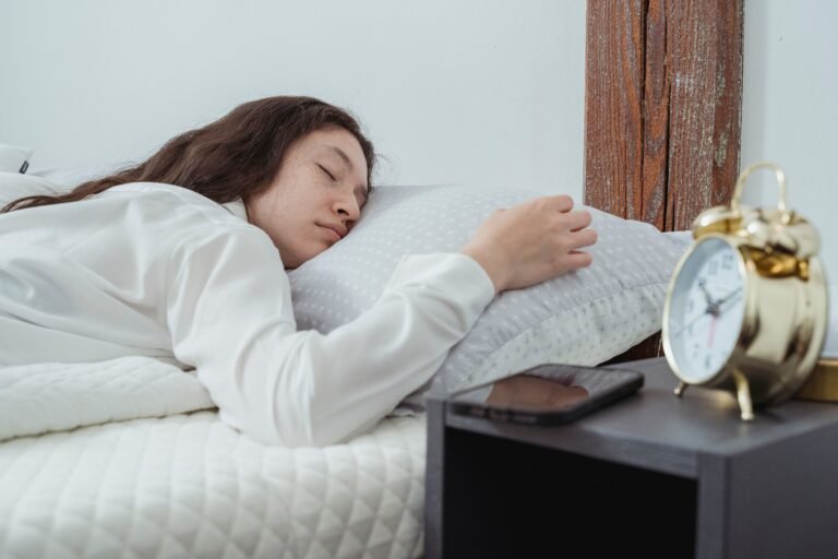 woman sleeping peacefully with alarm clock on nightstand